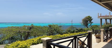 A balcony with a view of the ocean and a clear sky.
