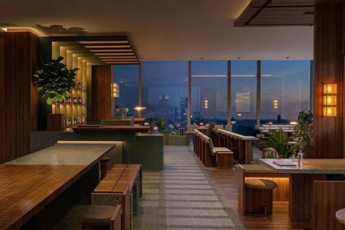 A modern interior with wooden furniture, a bar area, and large windows offering a city view.