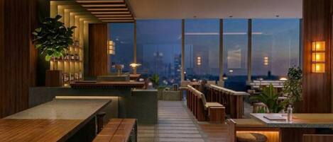 A modern interior with wooden furniture, a bar area, and large windows offering a city view.