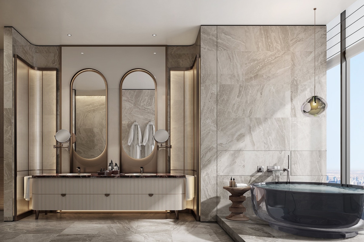 A modern bathroom with a large vanity, two mirrors, a bathtub, and a city view.