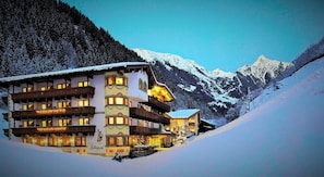 A multi-story hotel with balconies, set against a snowy mountain backdrop. - Alpin Lodge das Zillergrund (Mayrhofen)