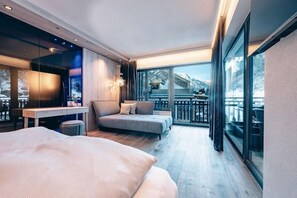 Una habitación de hotel moderna con balcón, cama, escritorio y sofá.