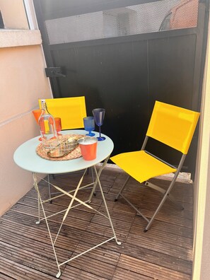 A small outdoor seating area with a table, chairs, and a bottle. - Charming, air-conditioned house near the highway and public transportation (Marseille)