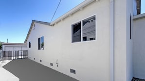 Een wit gebouw met een plat dak, een klein raam en een duidelijke deur.