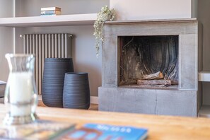 A fireplace with logs, a radiator, and two black vases on a shelf. - Villa NIKA - Mondello: Exclusive villa located in Fondoanfossi (Palermo)