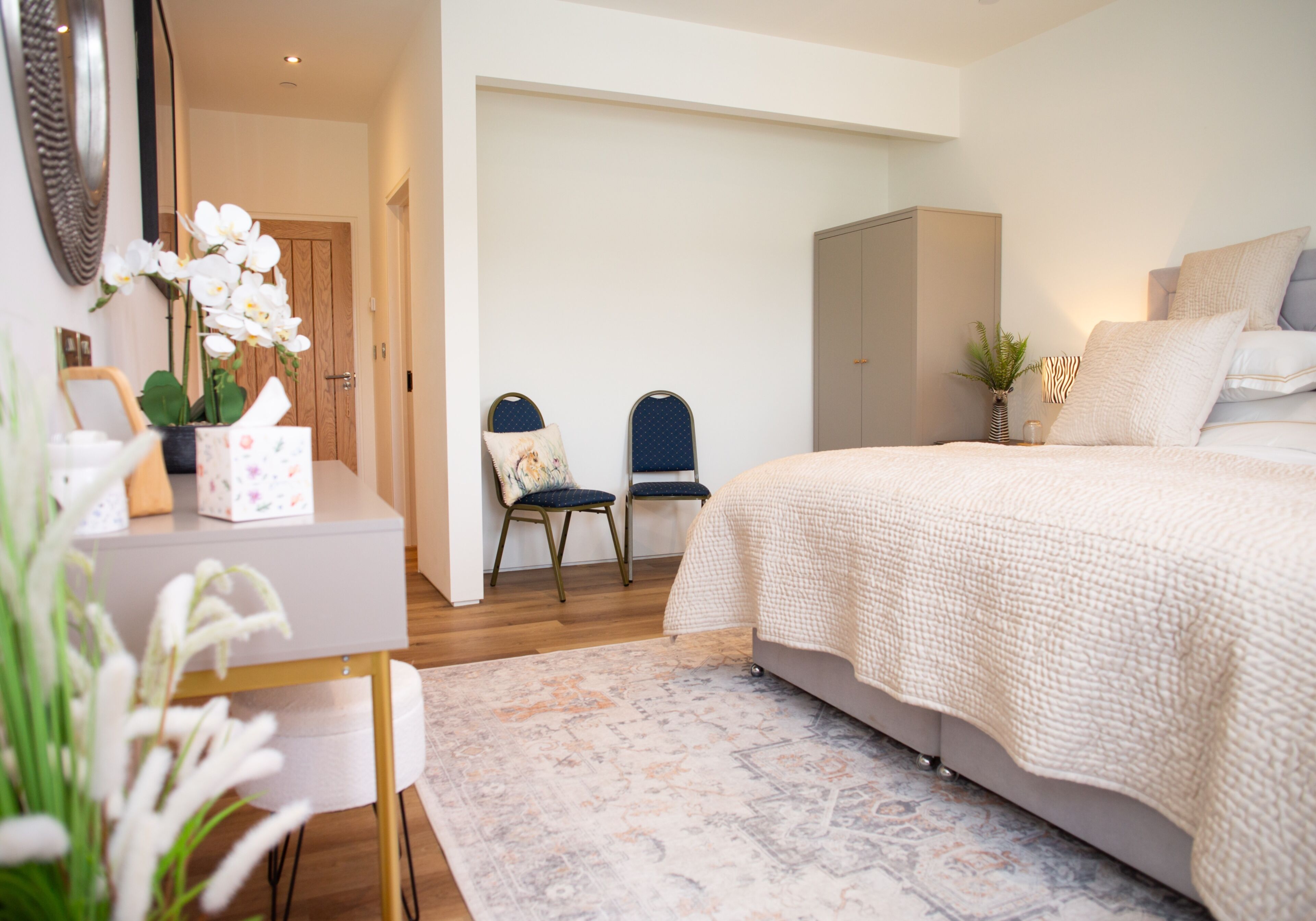 Ein Schlafzimmer mit Bett, Schreibtisch, Stühlen und Kleiderschrank.