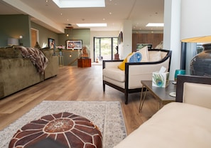 Un salon moderne avec un canapé, une table basse et un tapis à motifs.