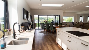 Una cucina moderna con un'isola grande, un'area pranzo con sedie e vista sull'esterno.