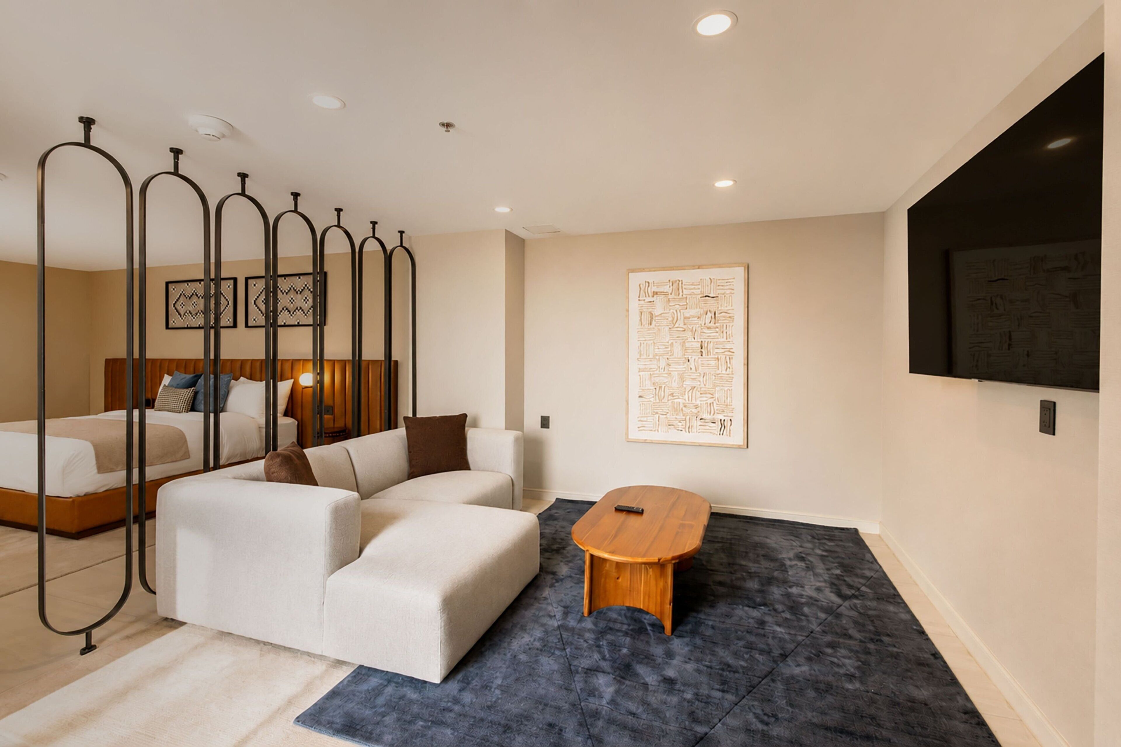 Une chambre à coucher moderne avec un lit, un canapé et une petite table.