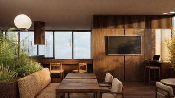 A modern interior with a sofa, dining table, chairs, a TV, and a laptop on a desk.