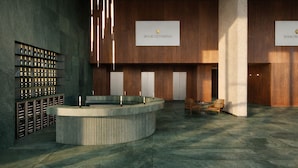 Eine Lobby mit Weinkühler, Empfangstresen und zwei Sesseln.