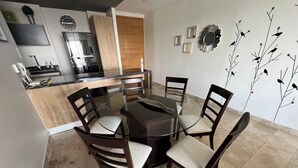 A modern kitchen with a built-in oven, a coffee machine, and a wooden cabinet. - Apartamento ejecutivo. Increible estancias largas (Santiago de Querétaro)