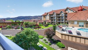 A hotel with multiple buildings, a swimming pool, and a view of mountains. - Downtown Pool View 2 Bdrm 449 On The Lake (Kelowna)