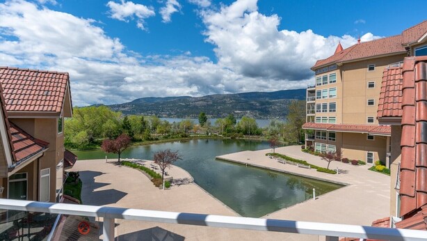 A residential building with a view of a river and mountains. - Downtown Pool View 2 Bdrm 449 On The Lake (Kelowna)