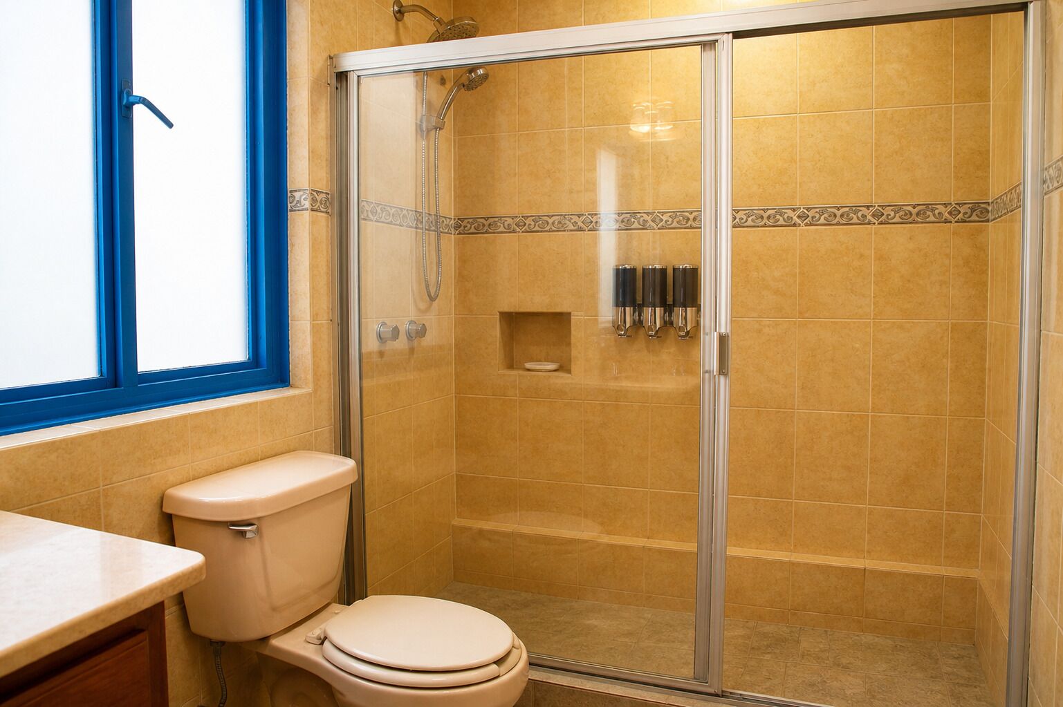 Ein Badezimmer mit Toilette, Duschkabine und Fenster.