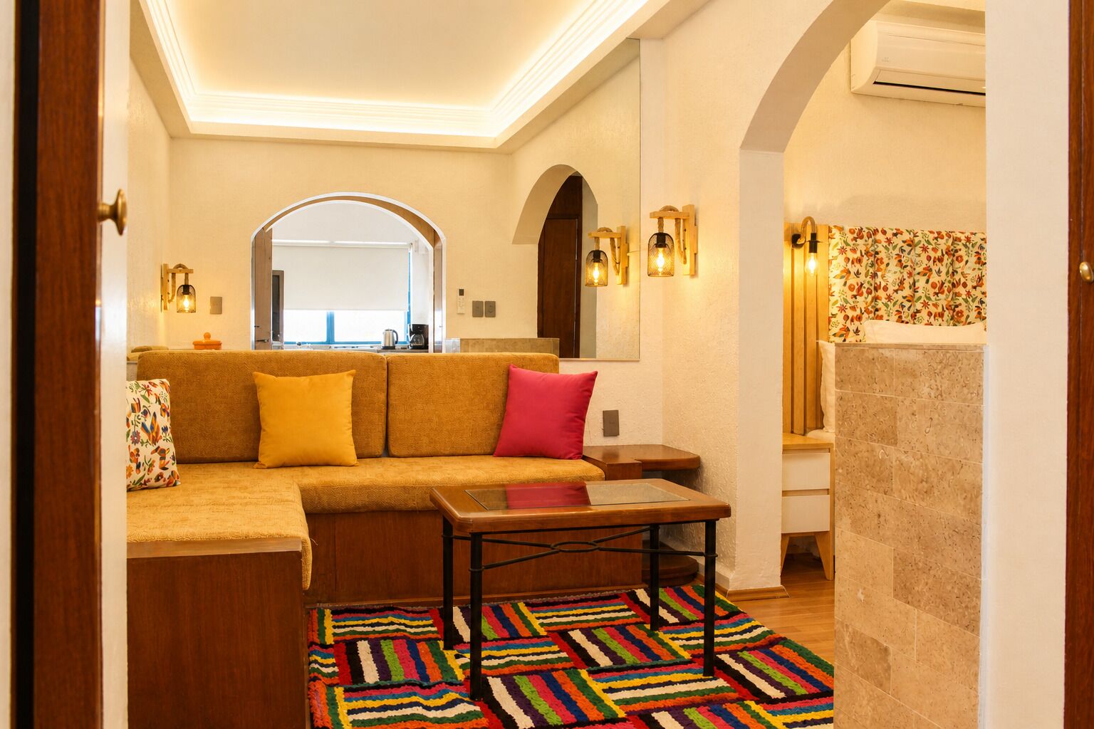 Una sala acogedora con un sofá, una mesita de centro y una alfombra colorida.