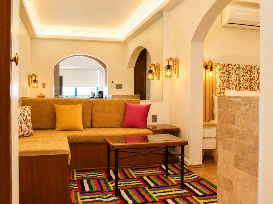 Una sala acogedora con un sofá, una mesita de centro y una alfombra colorida.