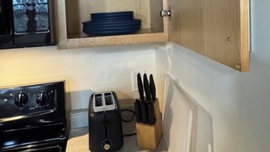 A kitchen with a microwave, toaster, and wooden utensil holder. - Historic Warehouse converted into Cozy Boutique Loft 305 (Fargo)