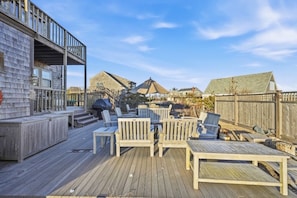 A wooden deck with outdoor furniture, a covered seating area, and a view of surrounding buildings. - Great sunsets on the beach in 3-bedroom Nantucket house with AC (Nantucket)