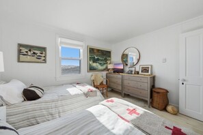 A bedroom with two beds, a dresser, a mirror, and artwork on the walls. - Great sunsets on the beach in 3-bedroom Nantucket house with AC (Nantucket)