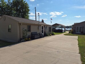 A residential area with single-story houses, a clear sky, and a lake in the background. - Stunning Lakefront house + guest house on beautiful Littlefield Lake (Lake)