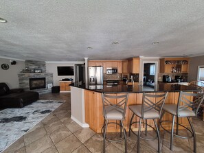 A spacious kitchen with a large island, wooden cabinets, and modern appliances. - Stunning Lakefront house + guest house on beautiful Littlefield Lake (Lake)