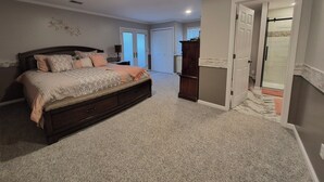 Ein Schlafzimmer mit einem großen Bett, einem Kleiderschrank und einem Badezimmer mit Duschkabine.