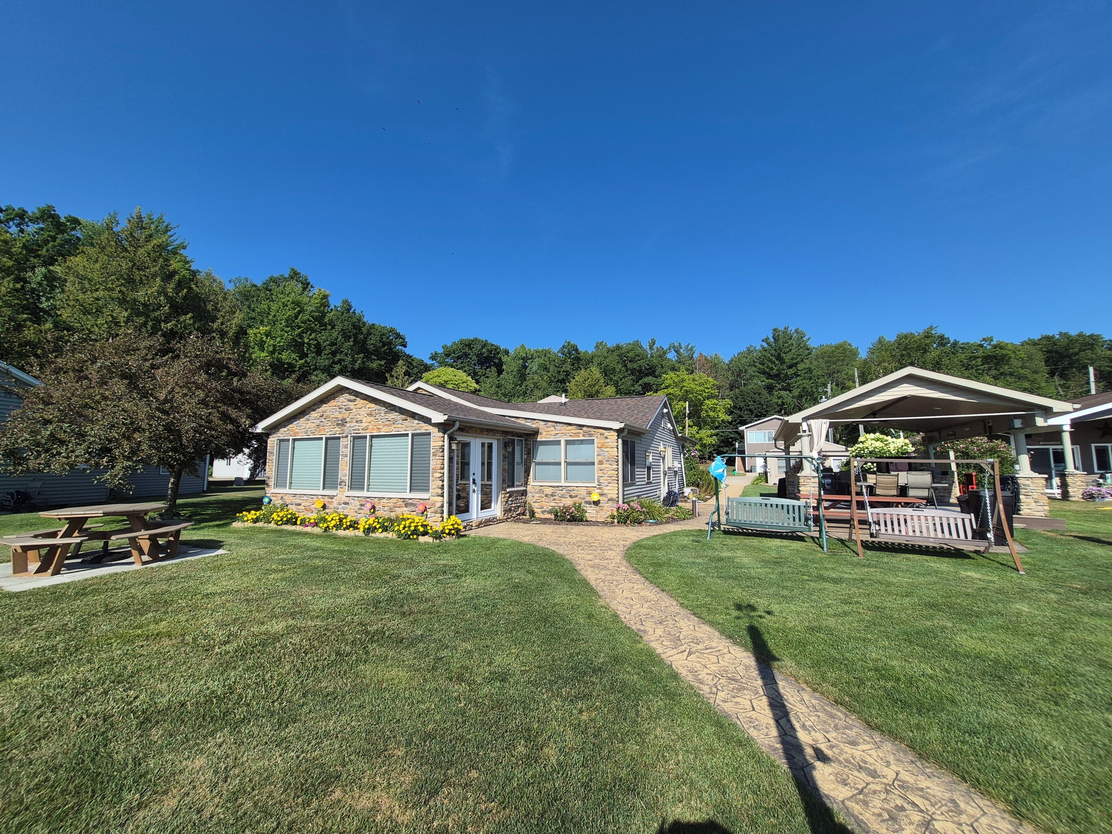 A residential area with houses, a picnic table, and a swing set.