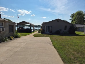 A residential area with a paved walkway leading to a covered patio area. - Stunning Lakefront house + guest house on beautiful Littlefield Lake (Lake)