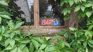 A wooden window sill with a neon sign spelling 'BAR' in red and blue lights.
