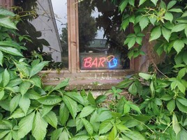 A wooden window sill with a neon sign spelling 'BAR' in red and blue lights.