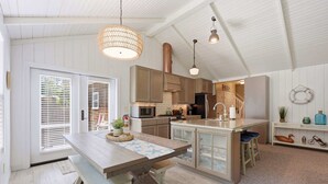 Una cocina con armarios de madera, una isla central e iluminación colgante.