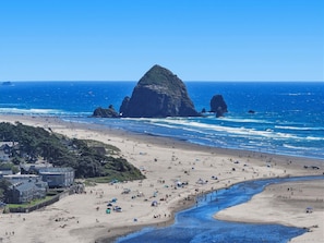 A beach with tents, a river, and rocky formations in the distance. - Coastal cottage with hot tub, close walk to beach (Cannon Beach)