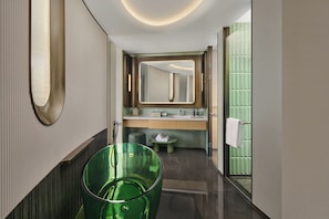 Un baño moderno con un espejo grande, un lavamanos verde y un inodoro.