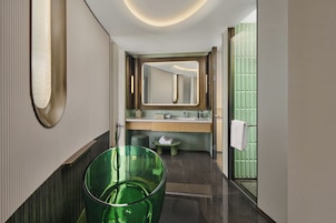 Un baño moderno con un espejo grande, un lavamanos verde y un inodoro.