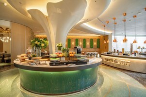 Una cocina moderna con una isla central, varios electrodomésticos y una exhibición de frutas.