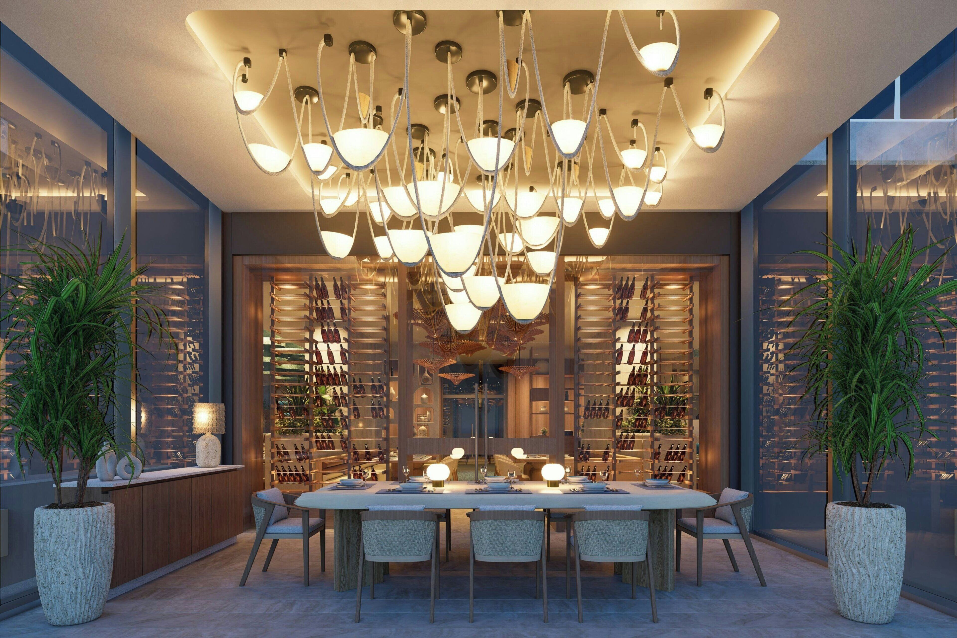 A modern dining area with a large table, multiple chairs, and a unique chandelier.