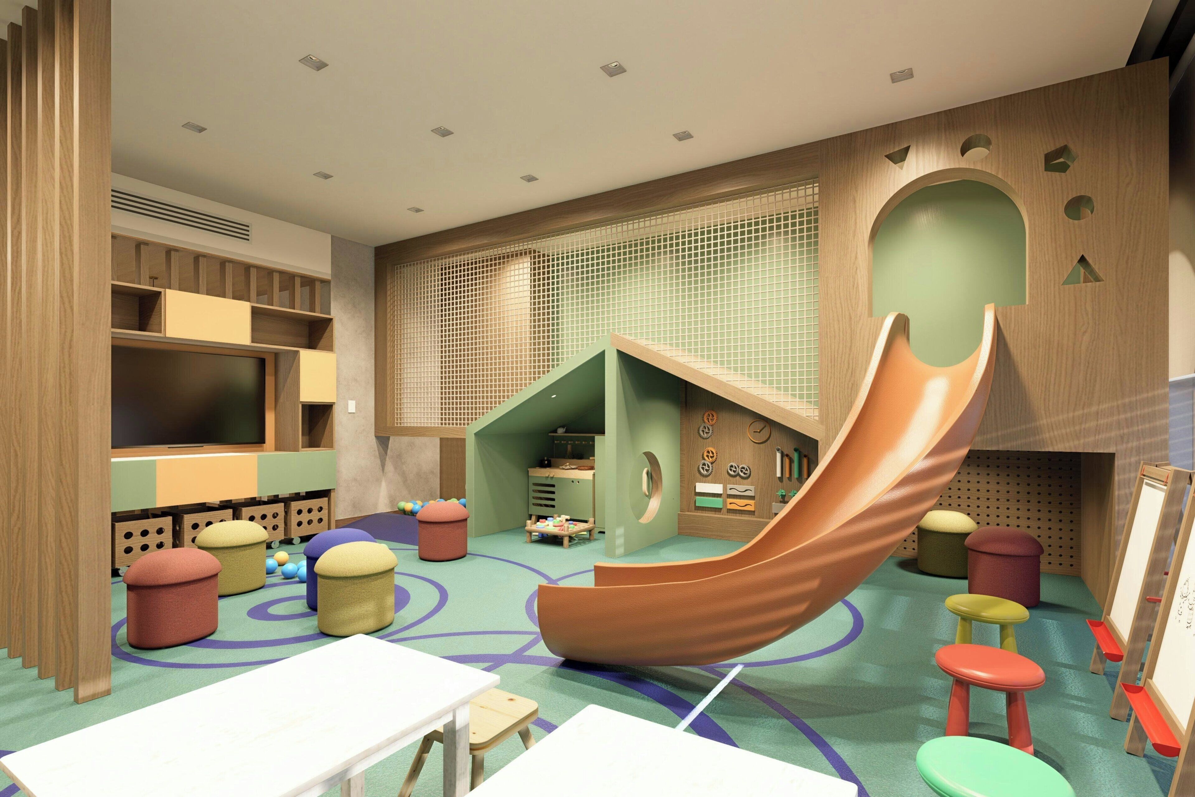 Ein Kinderspielzimmer mit Rutsche, Spieltischen und Stauraumeinheiten.