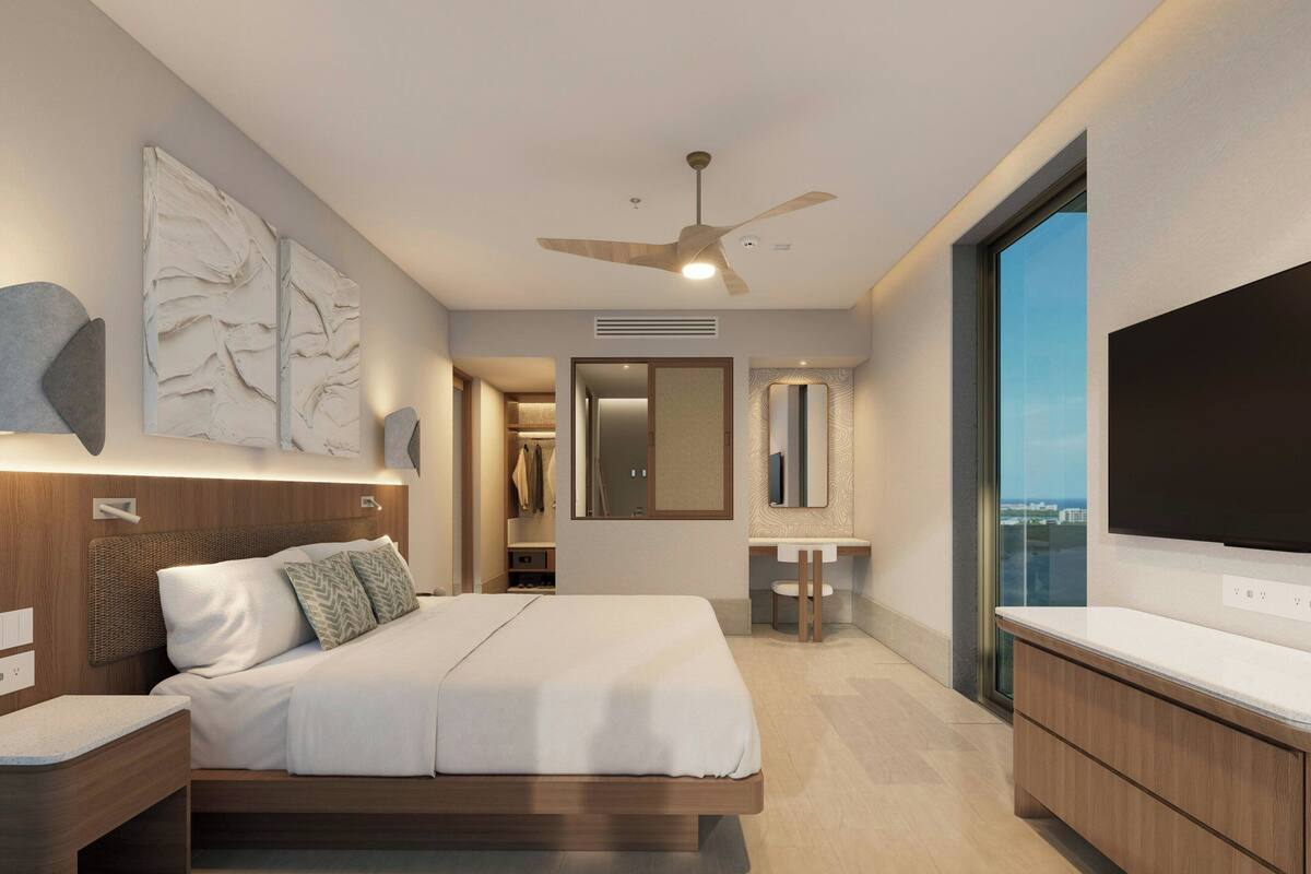 Une chambre d’hôtel moderne équipée d’un lit, d’une télévision, d’une salle de bain et offrant une vue sur la ville.