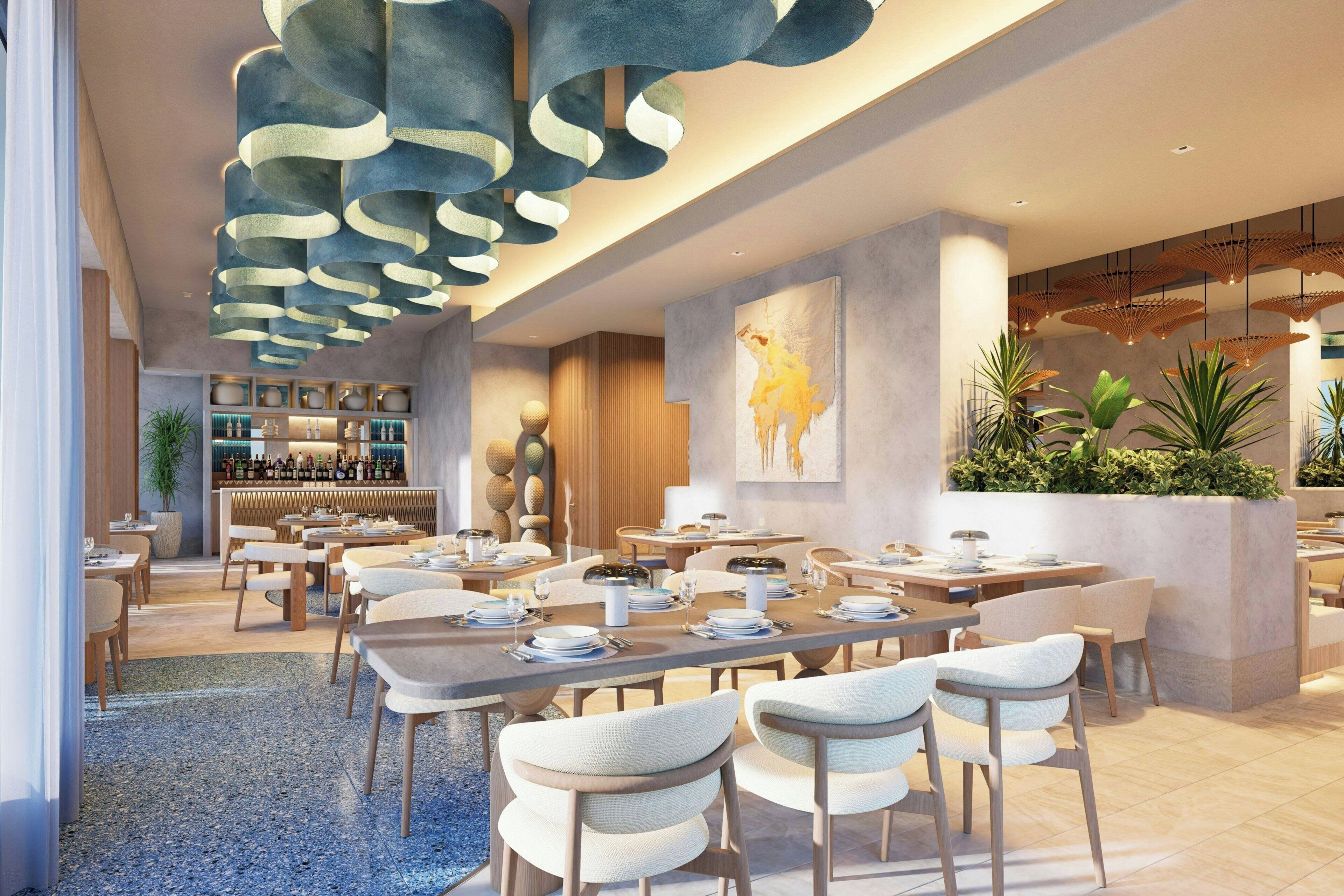 Un interior de restaurante moderno con asientos escalonados, una zona de bar y un cuadro grande en la pared.
