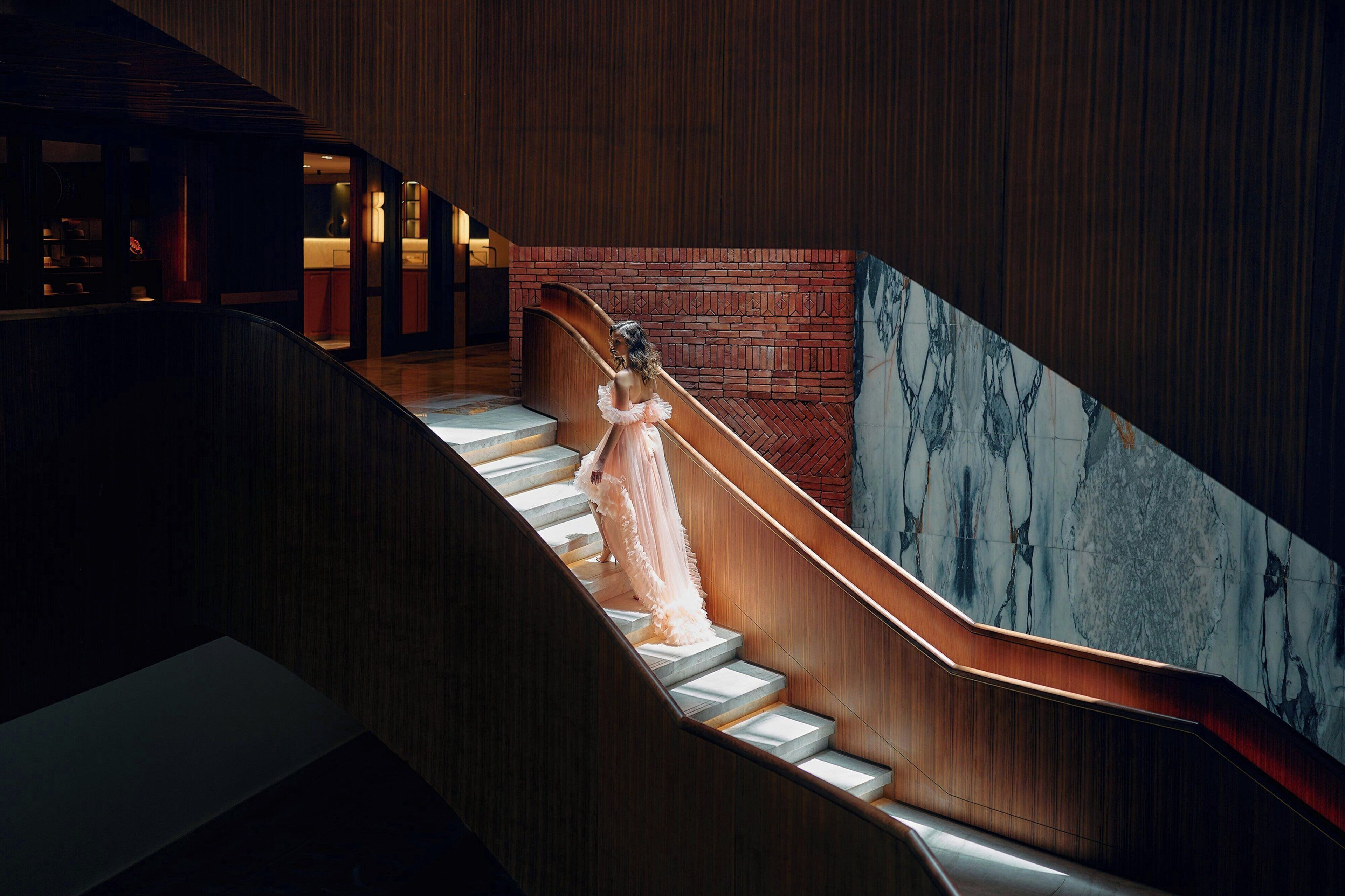 A staircase with a marble wall and wooden paneling.