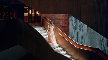 A staircase with a marble wall and wooden paneling.