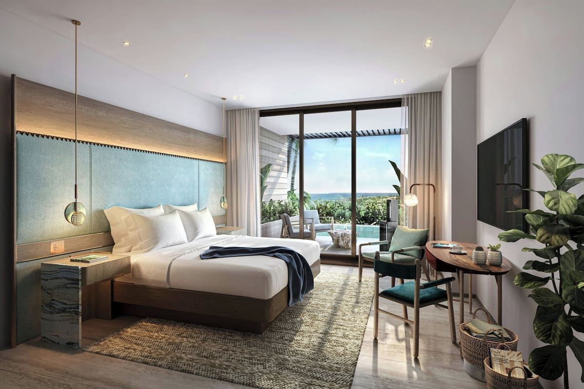 Een moderne hotelkamer met een groot bed, een bureau, een stoel, een televisie en een balkon met uitzicht.