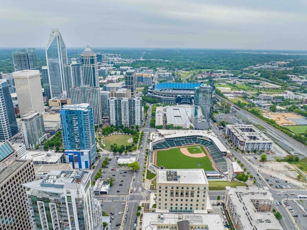 Un paisaje urbano con modernos rascacielos, un estadio de béisbol y una combinación de zonas comerciales y residenciales.