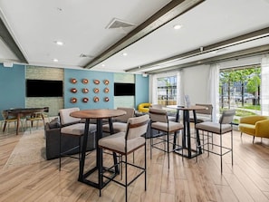 A modern interior with a dining area, sofas, and a large window with a view. - Luxury 1BR Near NoDa & Uptown Charlotte (Charlotte)