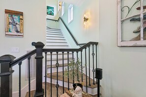 Eine Treppe mit Holzgeländer, einer Wandleuchte und einem gerahmten Bild.