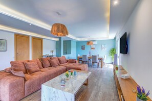 A modern living room with a sectional sofa, a marble coffee table, and a dining area with chairs and a table. - Mohammed VI | Elegant 3-bedroom apartment with a terrace (Maroc)