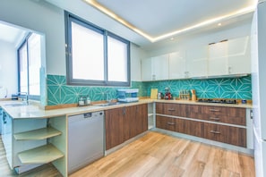 Eine moderne Küche mit Geschirrspüler, Holzschränken und einem Fenster.
