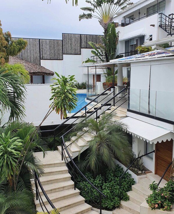A modern multi-level house with a pool, outdoor staircase, and lush greenery. - Boutique Sal (Acapulco)