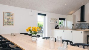 A modern kitchen with white cabinets, a wooden countertop, and a black range hood. - 5 Star Holiday Home in Hadsund (Hadsund)